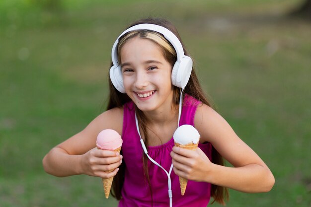 Vista frontal de la niña con conos de helado