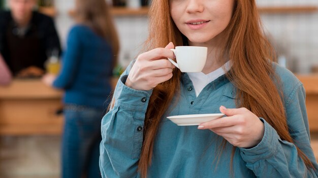 Vista frontal de niña disfrutando de café