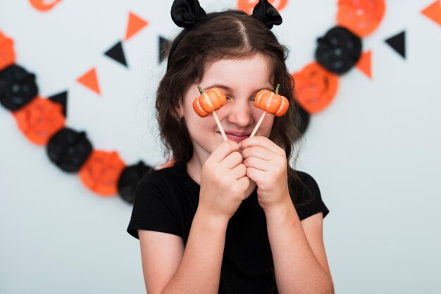 Vista frontal de una niña con dulces de calabaza