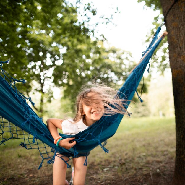 Vista frontal de la niña feliz en hamaca