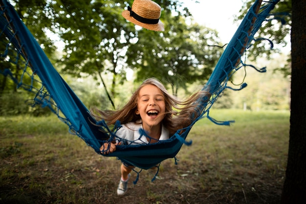 Vista frontal de la niña feliz en hamaca