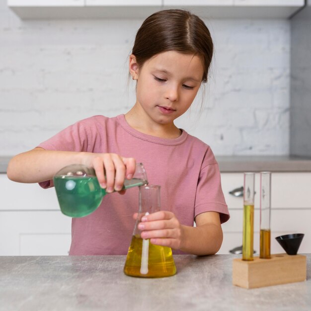 Vista frontal de la niña haciendo experimentos con tubos de ensayo