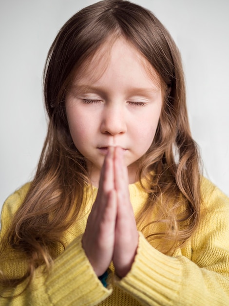 Foto gratuita vista frontal de niña linda rezando