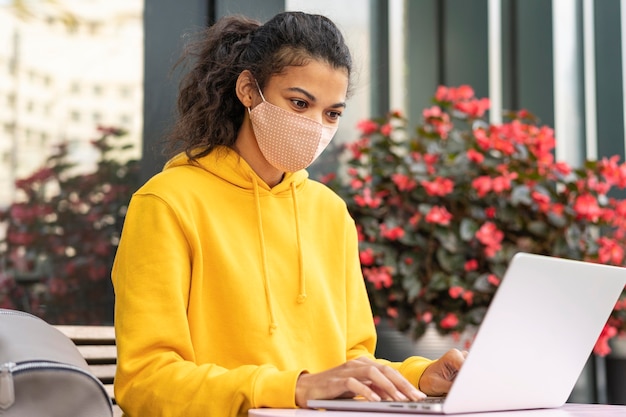 Foto gratuita vista frontal de la niña con mascarilla en la calle