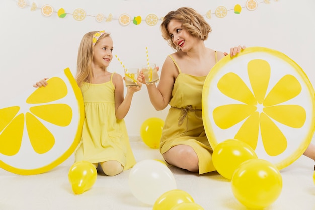 Foto gratuita vista frontal de niña y mujer brindando con limonada