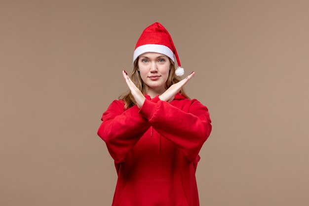 Vista frontal de la niña de Navidad mostrando signo de prohibición sobre fondo marrón modelo vacaciones Navidad