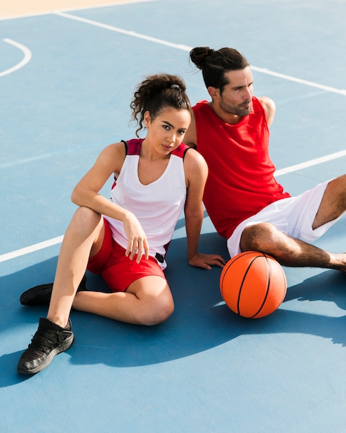 Vista frontal de niña y niño con baloncesto