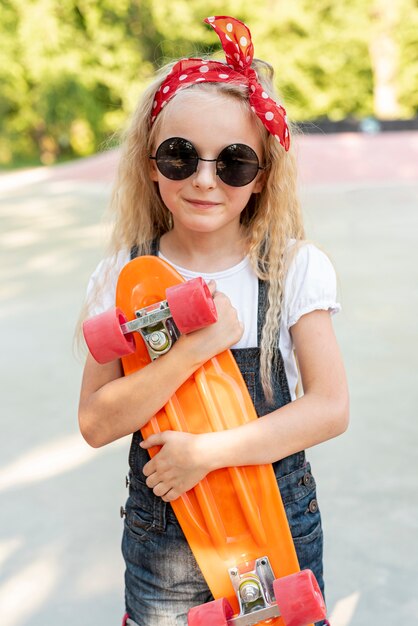 Vista frontal de la niña con patineta