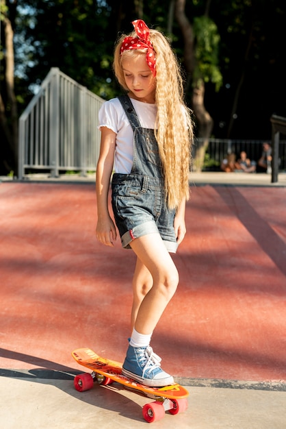 Foto gratuita vista frontal de la niña en patineta