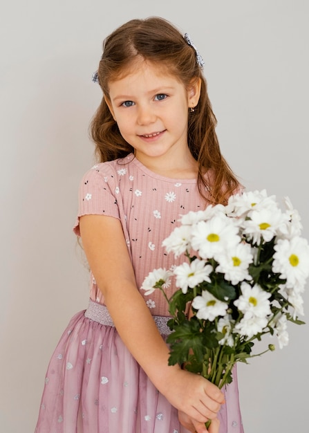 Vista frontal de la niña con ramo de flores de primavera