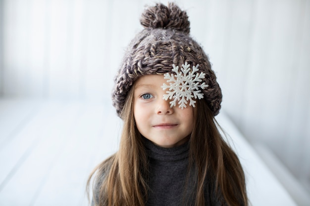 Vista frontal niña rubia con sombrero de invierno