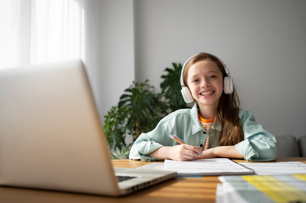 Vista frontal niña sonriente con auriculares