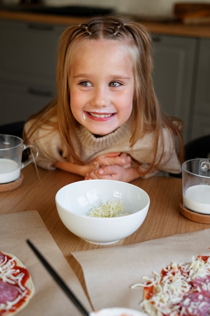 Vista frontal niña sonriente cocinando