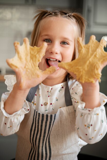 Vista frontal niña sonriente cocinando