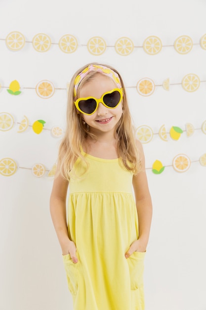 Vista frontal de la niña sonriente con gafas de sol