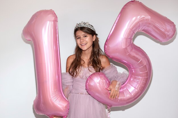 Vista frontal niña sonriente con globos