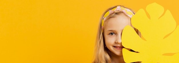 Foto gratuita vista frontal de la niña sonriente con hoja