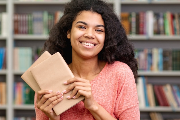 Foto gratuita vista frontal niña sonriente con libros