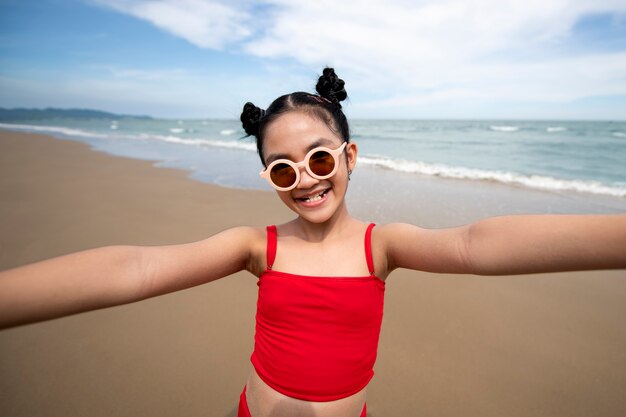 Vista frontal niña sonriente en la playa