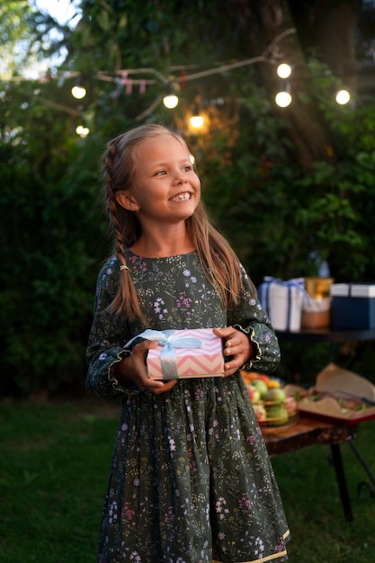 Foto gratuita vista frontal niña sonriente con regalo