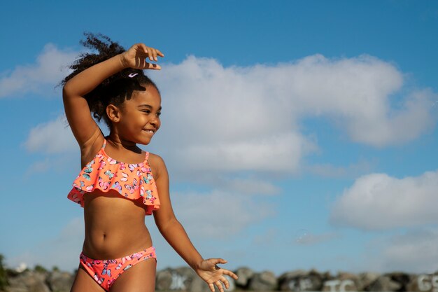 Vista frontal niña sonriente con traje de baño