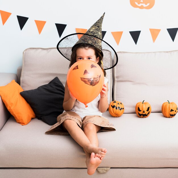 Vista frontal niña sosteniendo un globo de halloween