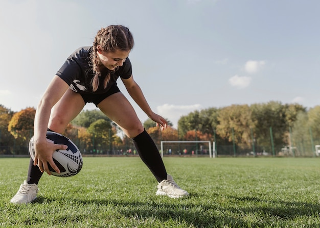 Vista frontal niña sosteniendo una pelota con espacio de copia