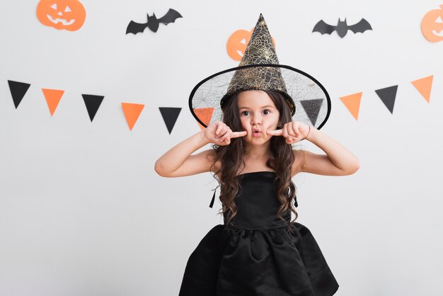 Vista frontal niña en traje de bruja para halloween