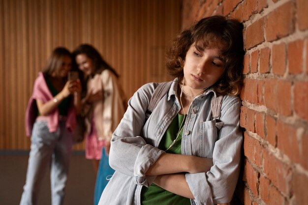 Vista frontal niña triste siendo intimidada en la escuela