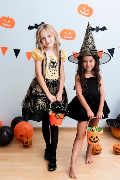 Vista frontal de niñas en traje de bruja para halloween