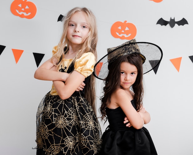 Vista frontal de niñas en traje de bruja para halloween