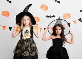 Foto gratuita vista frontal de niñas en traje de bruja para halloween