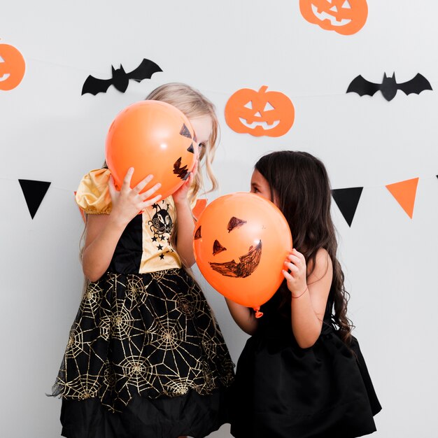 Vista frontal de niñas en traje de bruja para halloween