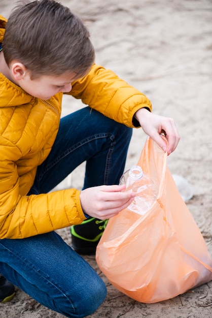 Vista frontal del niño con bolsa de plástico