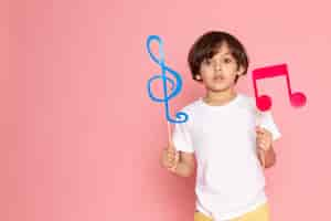 Foto gratuita una vista frontal de niño con carteles de colores en camiseta blanca en el espacio rosa