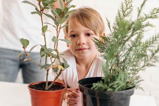 Vista frontal del niño en casa con papá mirando plantas