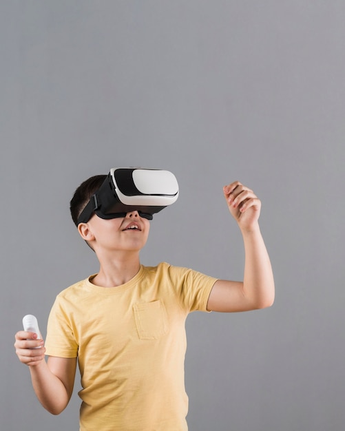 Vista frontal del niño con casco de realidad virtual con espacio de copia