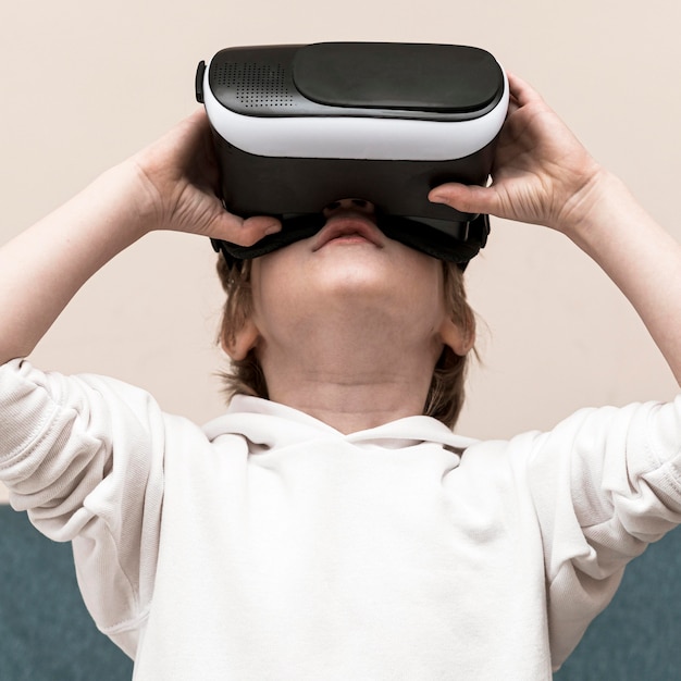 Foto gratuita vista frontal del niño con casco de realidad virtual