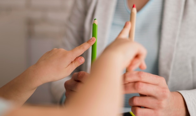 Vista frontal del niño contando en casa con lápices