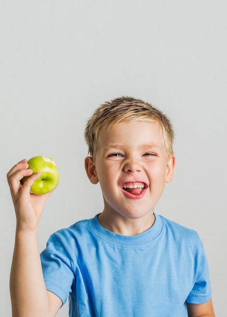 Vista frontal niño feliz con una manzana