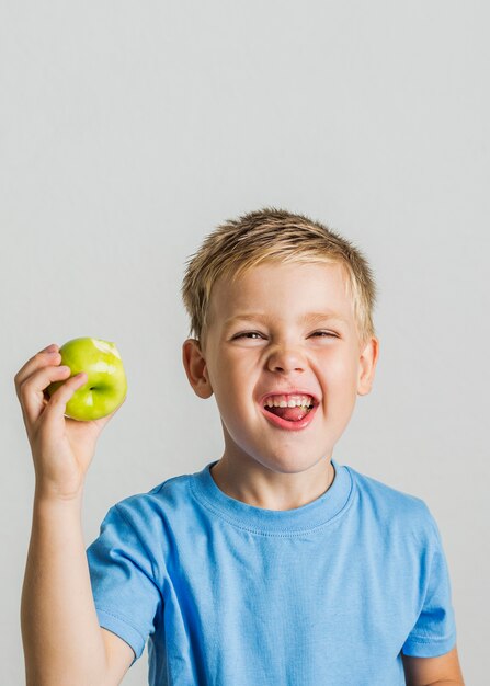 Vista frontal niño feliz con una manzana