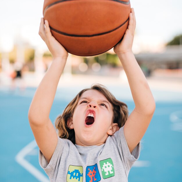 Vista frontal del niño jugando baloncesto