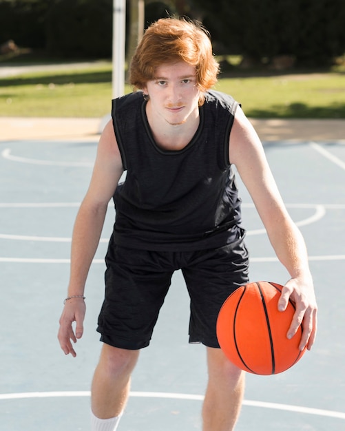 Vista frontal del niño jugando baloncesto