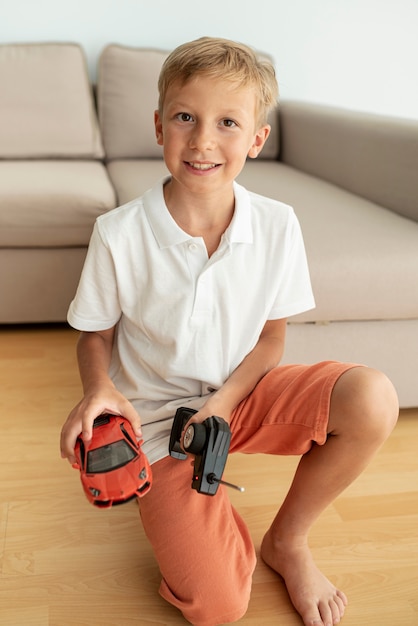 Foto gratuita vista frontal del niño jugando con un carro eléctrico.