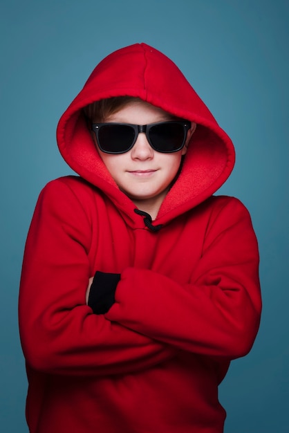 Foto gratuita vista frontal del niño moderno con gafas de sol posando