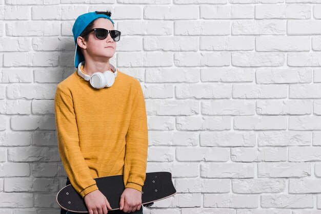 Vista frontal del niño moderno con patineta con espacio de copia