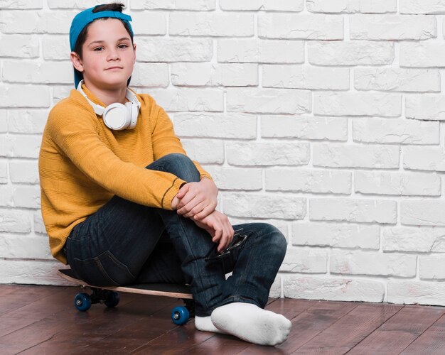 Vista frontal del niño moderno con patineta