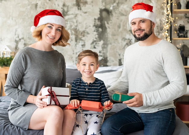 Vista frontal del niño y los padres juntos el día de Navidad