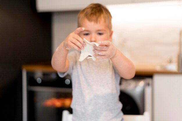 Vista frontal del niño pequeño que cocina en casa