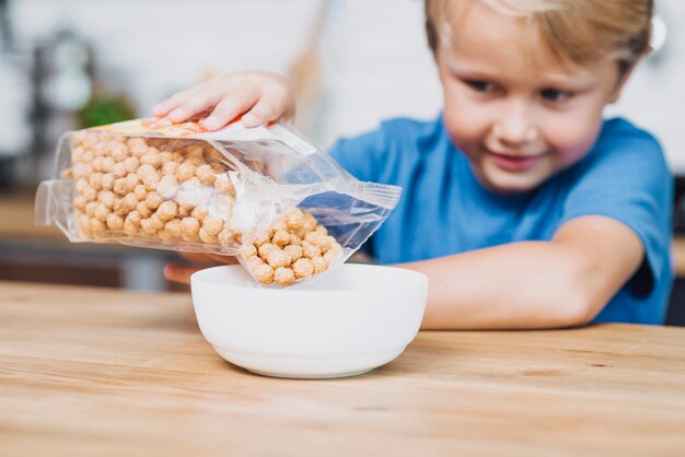 Vista frontal niño preparándose para el desayuno